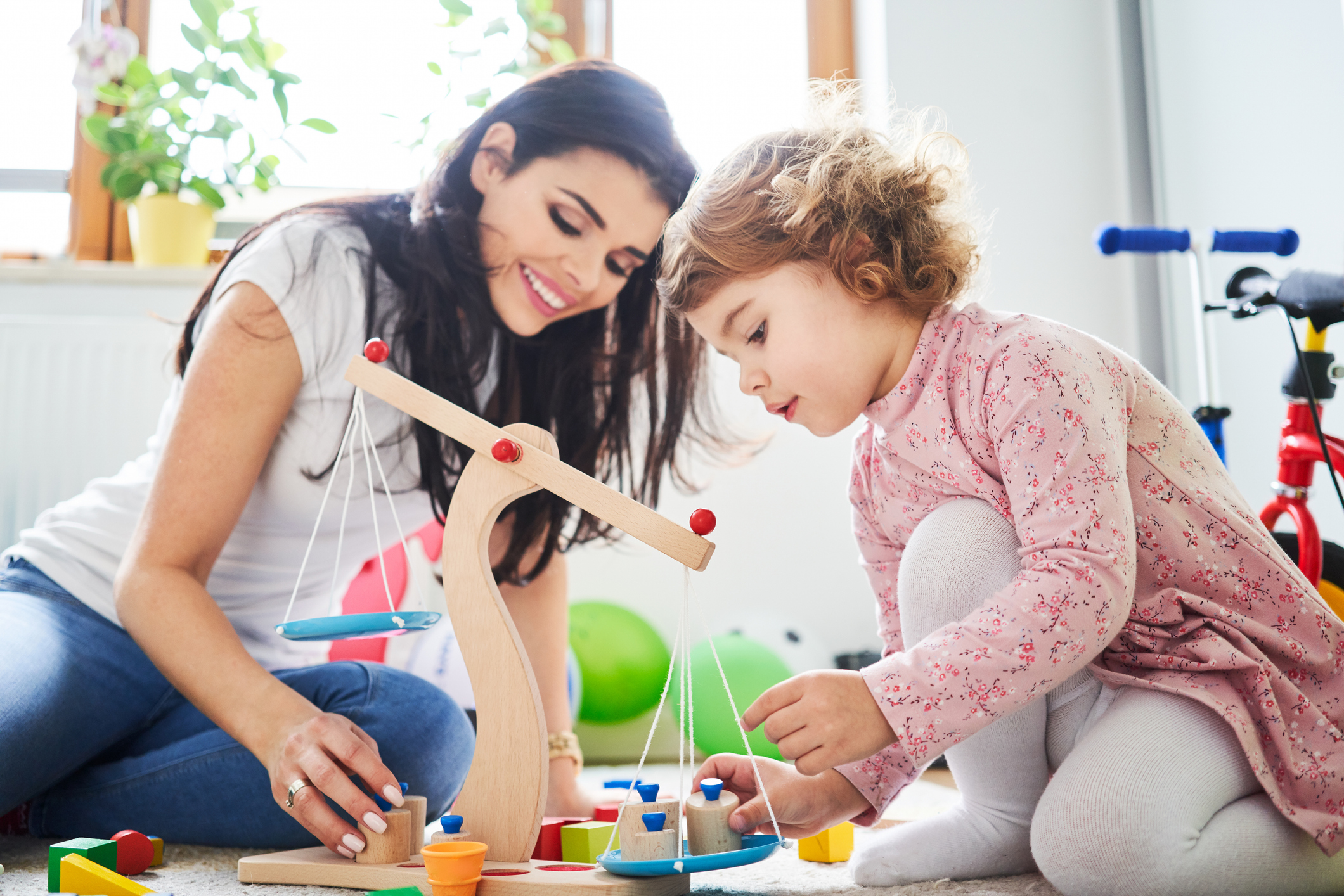 Mother spending time with her daughter playing with toys