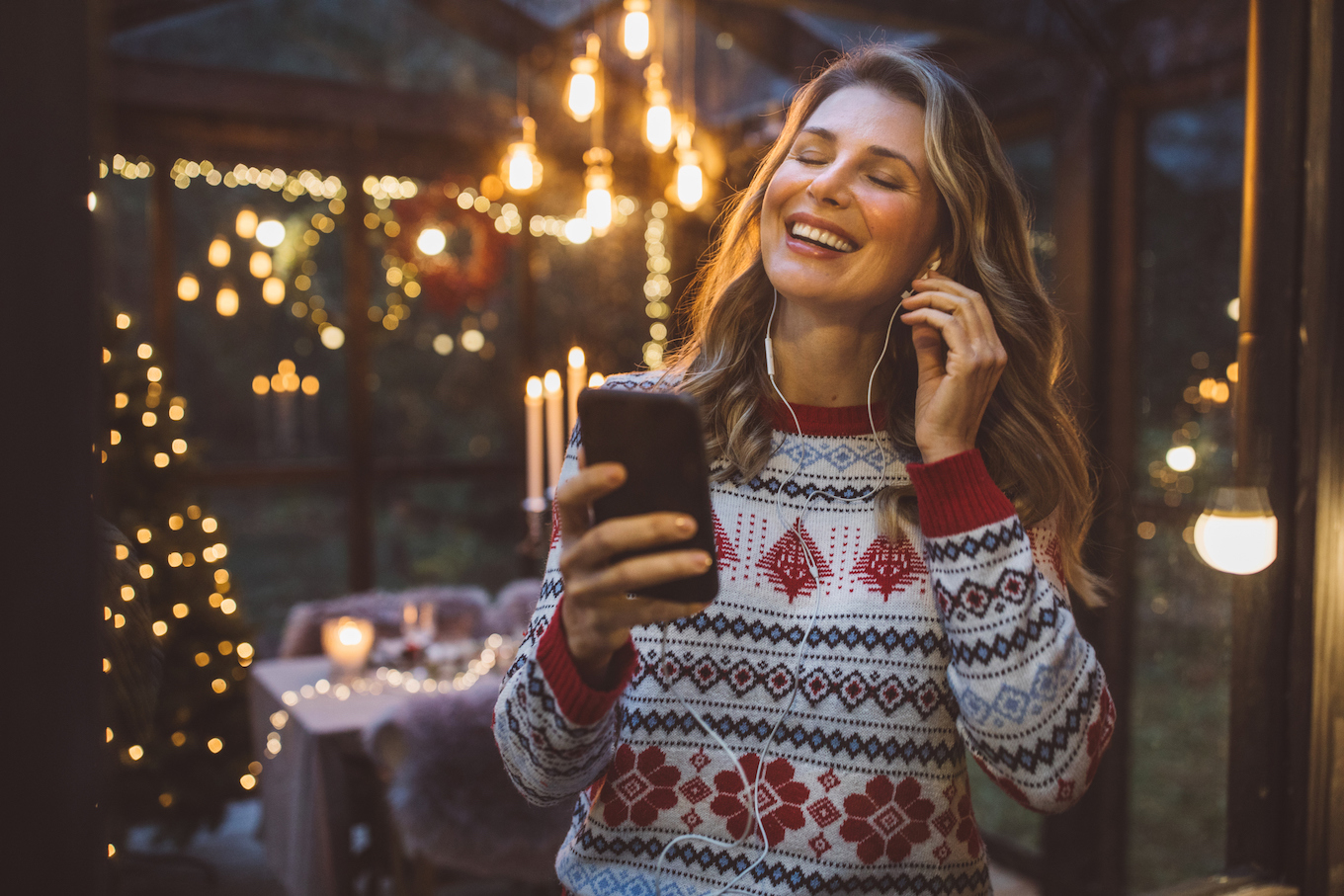 Woman in a sweater listening to music