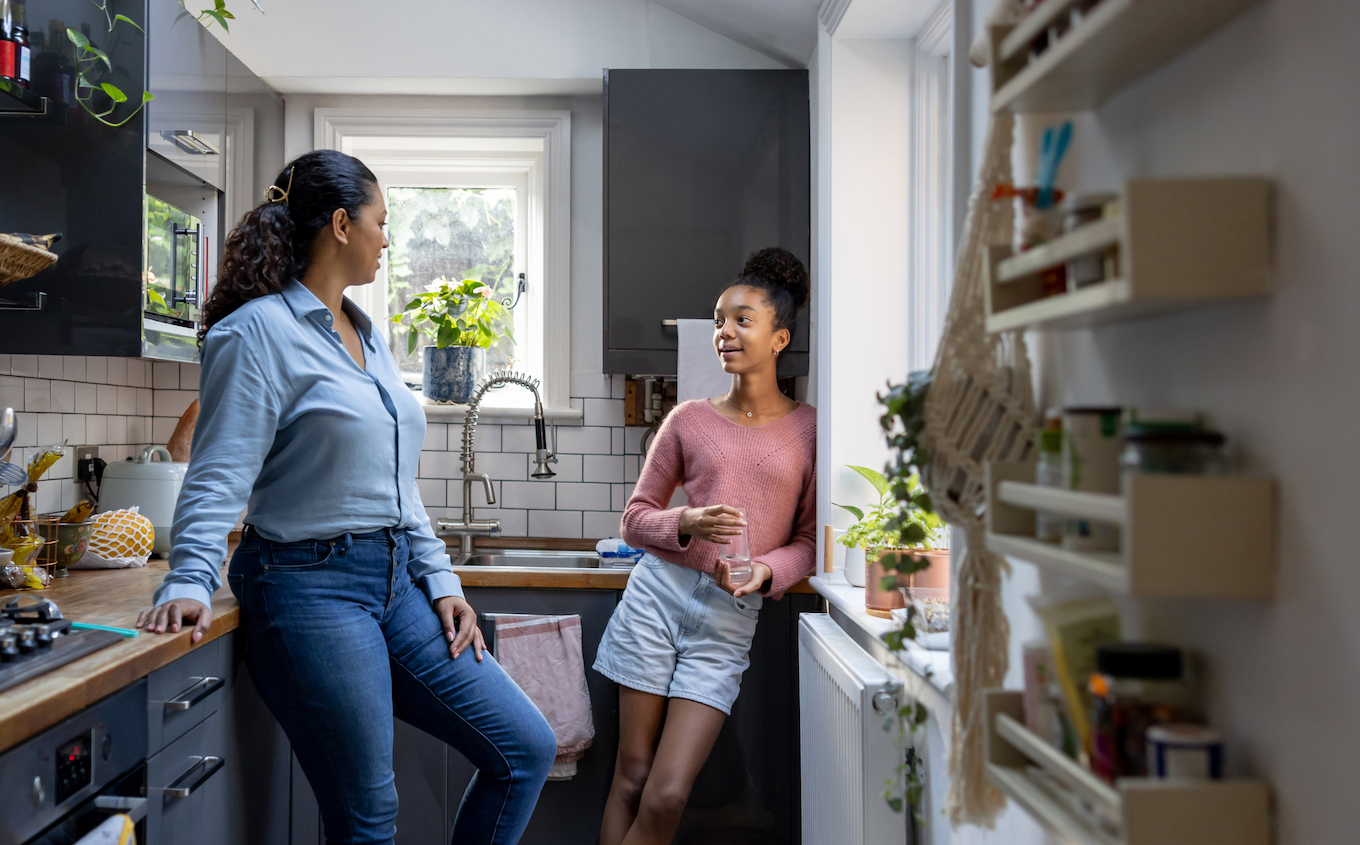 Mom and daughter talking in kitchen