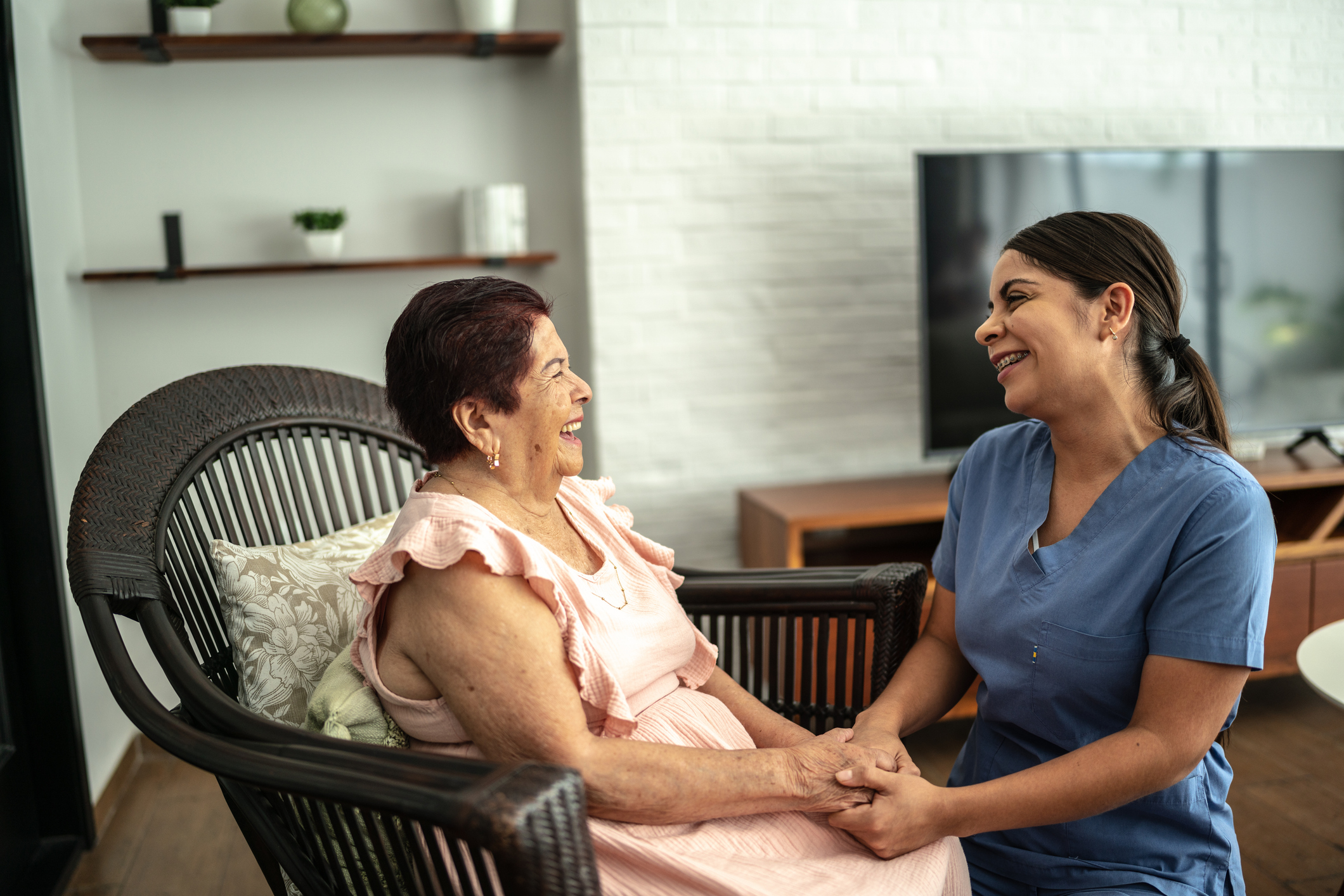 Home caregiver talking with a senior woman in a nursing home
