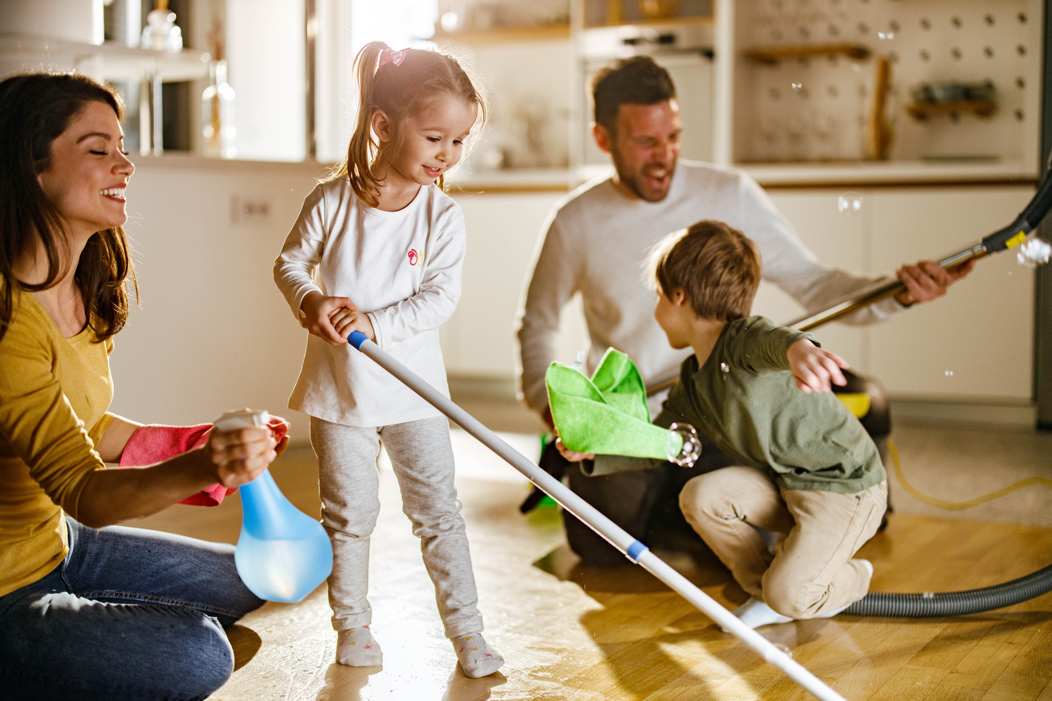 Happy family having fun while doing chores around the house.