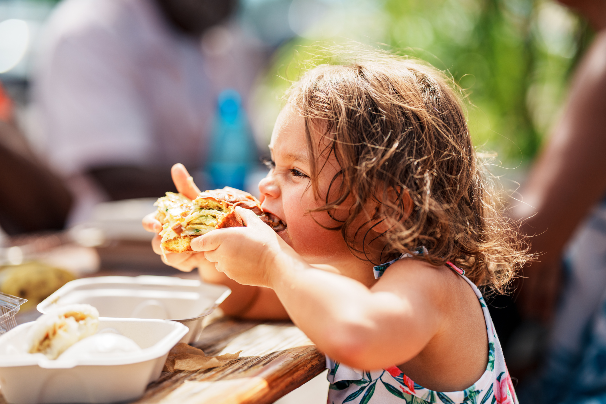Eurasian girl eating street food while vacationing in Hawaii